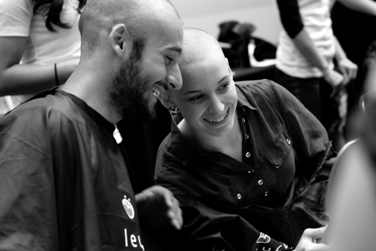 Une homme et une femme ont les cheveux rasés et se regardent en souriant dans un miroir